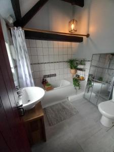 a bathroom with a tub and a sink and a toilet at Yewtree Cottage in Strensall