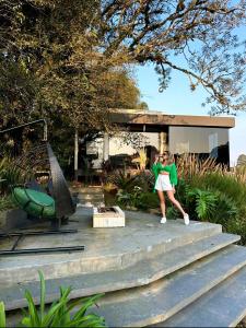 una mujer parada en las escaleras frente a un edificio en La Contemporânea Cabanas prox a cidade vista para ponto turístico, en Urubici