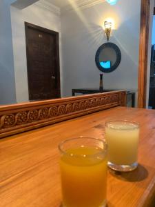 un vaso de zumo de naranja sentado en una mesa de madera en Z Pyramids Inn, en El Cairo