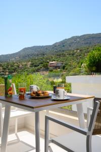 a table with food and drinks on a balcony at Philoxenia Luxury Apartment in Kritsa