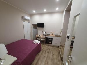 Dormitorio pequeño con cama morada y lavamanos en B&B la casa di Vale, en Marigliano
