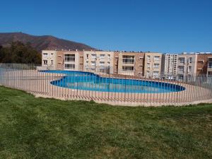 a large swimming pool in front of a building at Acogedor Departamento en tranquilo balneario, Papudo in Papudo