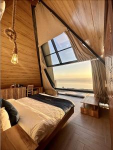 a bedroom with a bed and a large window at Deadsea OCTAGON in Madaba