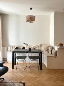 a living room with a table and a couch at LuxeLevallois chic stay with balcony 800 meters from Paris in Levallois-Perret