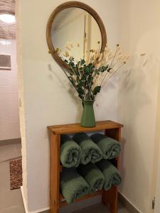 ein Badezimmer mit einem Spiegel und einer Vase mit Handtüchern in der Unterkunft Rittergut Hirschbach - Verwalterhaus in Hirschbach + 6 Fotos