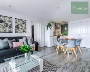 a living room with a black couch and a table at Stunning Two Bed Apartment By PureStay Short Lets & Serviced Accommodation Manchester With Free Parking & WiFi in Manchester