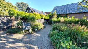 un jardín con una pasarela de ladrillo junto a un edificio en Weberhof Apartment 6, en Münster