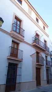 a white building with two balconies on it at Hospedería do Porto in El Puerto de Santa María