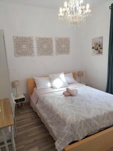 1 dormitorio con 1 cama con lámpara de araña en El Coqueto de Vallecas, en Madrid