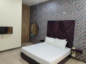 a bedroom with a bed and a wall with a tv at Hotel The Taj Multan in Multan