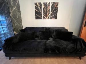 un sofá negro sentado en una sala de estar en Supreme City Heart Apartment, en Alexandroupoli