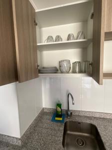 a kitchen counter with a sink and some dishes at Departamento Lynch Iquique in Iquique