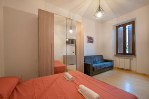 een slaapkamer met een rood bed en een blauwe bank bij [CantikHouse] free wifi & smarTV in Verona