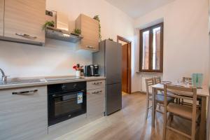 een keuken met een tafel en een fornuis top oven bij [CantikHouse] free wifi & smarTV in Verona