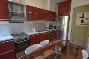 a kitchen with wooden cabinets and a stainless steel refrigerator at Classic apt. on Liberty Square in Tbilisi City