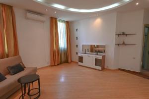 a living room with a couch and a kitchen at Classic apt. on Liberty Square in Tbilisi City