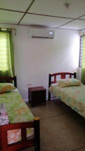 um quarto com duas camas e uma mesa em Villa Myrian em Villanueva