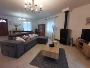 ein Wohnzimmer mit einem Sofa und einem Tisch in der Unterkunft Endroit paisible, Périgueux, maison avec piscine in La Garde