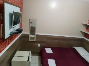 a small room with a bed and a tv at Recanto das Palmeiras Temporada,prox.UFPI in Parnaíba