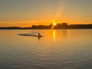 osoba w łodzi na jeziorze o zachodzie słońca w obiekcie Loft Unterkunft in Hügelsheim w mieście Hügelsheim
