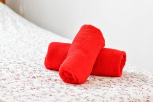 two red towels sitting on top of a bed at Les Cerisiers - Appartement de Standing au Centre de Namur in Namur +18 photos