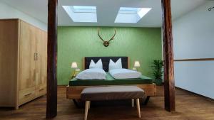 a bedroom with a bed with a green wall at Traditions - Hotel "Zur Tanne" in Wernigerode