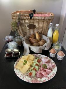 a table with a plate of food and a basket of bread at Bed and Breakfast Bakrust, met privé sauna Putten in Putten