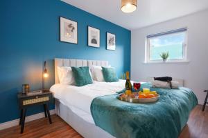 a blue bedroom with a bed with a tray of fruit on it at Stylish Apartment - Walking Distance to the City Centre - Free Parking, Fast Wi-Fi and SmartTV with Netflix by Yoko Property in Coventry