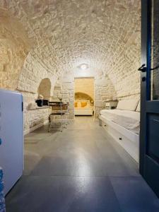 um quarto com uma cama numa parede de pedra em Scardino Trulli em Locorotondo