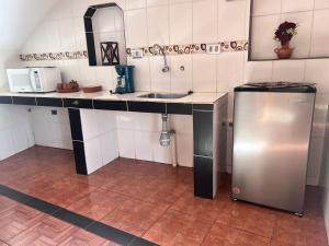 a small kitchen with a sink and a refrigerator at VIRREYES HOTEL in Potosí