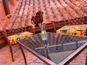 a glass table with a vase of flowers on it at VIRREYES HOTEL in Potosí