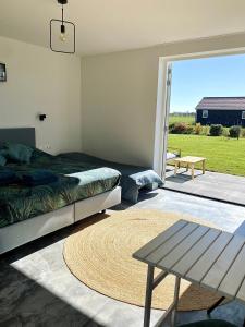 een slaapkamer met een bed en een tafel en een patio bij Bed no breakfast de Kapitein in 't Horntje