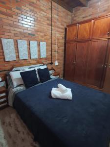 - une chambre avec un grand lit et un mur en briques dans l'établissement Duplex estilo europeu Ednamar Apartamentos Bérgamo, à Gramado