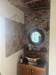 a bathroom with a sink and a mirror at Bridie -rose rural shepherd hut , sleeps 4 with wood fuel hot tub -mini safari -on your doorstep small exotic animals in Kington