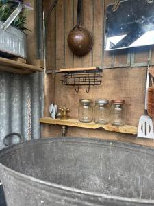a bath tub in a room with jars on a wall at Bridie -rose Sleeps 4 to 6 with hot tub at extra cost in Kington