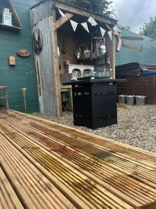 a wooden deck with a kitchen in a backyard at Bridie -rose Sleeps 4 to 6 with hot tub at extra cost in Kington