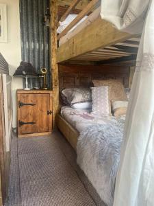 a bedroom with a bunk bed with a wooden frame at Bridie -rose Sleeps 4 to 6 with hot tub at extra cost in Kington