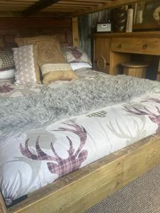 ein Bett mit einem Holzrahmen in einem Zimmer in der Unterkunft Bridie -rose Sleeps 4 to 6 with hot tub at extra cost in Kington