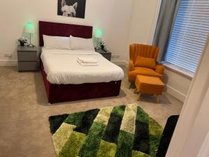 ein Schlafzimmer mit einem großen Bett und einem Stuhl in der Unterkunft Spacious 2 bedrooms Apartment Woolwich Arsenal in Woolwich