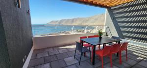 un tavolo e sedie su un balcone con vista sull'oceano di Departamento Lynch Iquique a Iquique
