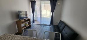 a living room with a couch and a television at Departamento Lynch Iquique in Iquique