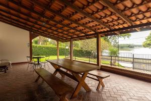 una mesa de picnic y sillas en un patio con vistas al agua en Pousada Wafeh Pampulha Suítes, en Belo Horizonte