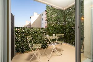 a green wall with chairs and a table on a balcony at Appartement tout équipé à 6 minutes de la Gare St Charles in Marseille
