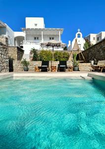a large pool of water in front of a house at Sofos Suites Mykonos in Mýkonos City