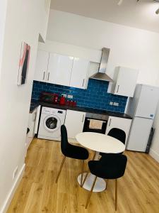 eine Küche mit einem Tisch und Stühlen im Zimmer in der Unterkunft Spacious 2 bedrooms Apartment Woolwich Arsenal in Woolwich