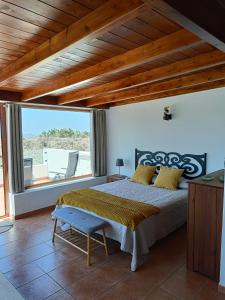 een slaapkamer met een bed en een groot raam bij La Morada in Artenara