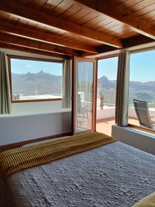 a bedroom with a bed with a view of the mountains at La Morada in Artenara