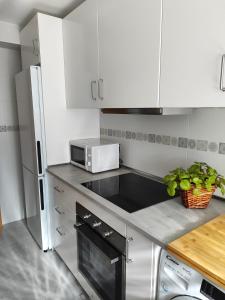 cocina con armarios blancos y microondas en Apartamento en Torre del Mar, en Torre del Mar