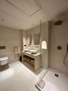 a bathroom with two sinks and a toilet at Hotel Avenida in Zaragoza