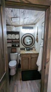 a small bathroom with a toilet and a mirror at Enjoy Ozark History in Style! in Hasty